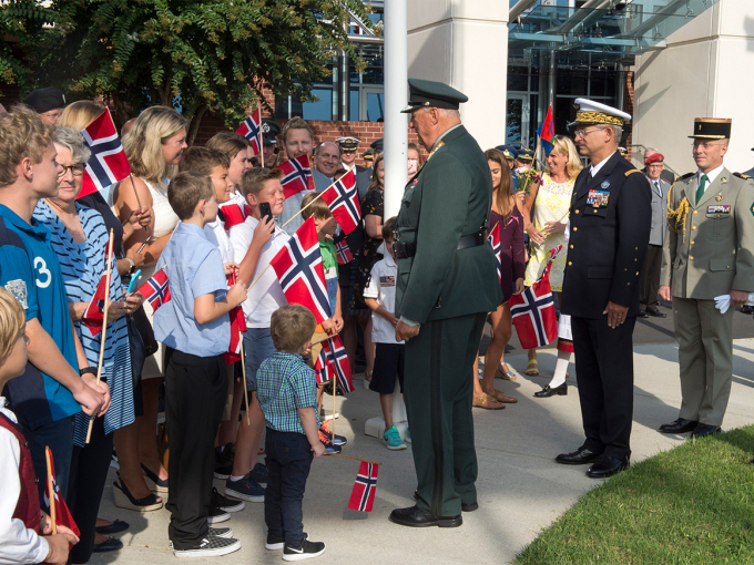 King Harald spoke with some of the children that greeted him on his arrival at the NATO Headquarters. Photo: NATO